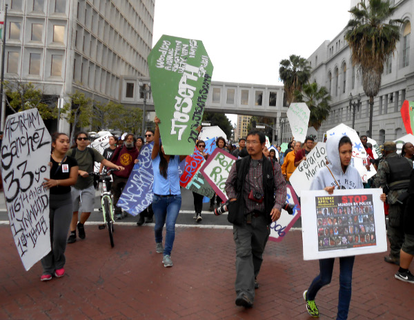 Protesters carry cardboard coffins representing people killed by police