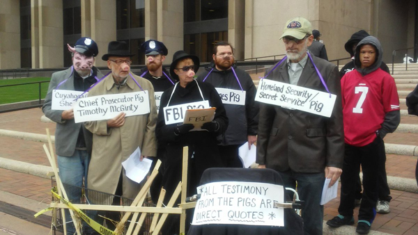 Revcoms dressed as pigs stand on the steps of the Justice Center in downtown Cleveland.