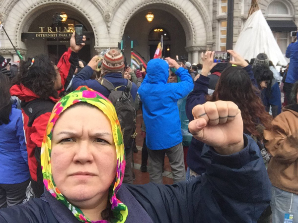 In front of Trump Hotel in D.C., marchers chant "Trump must go!" 