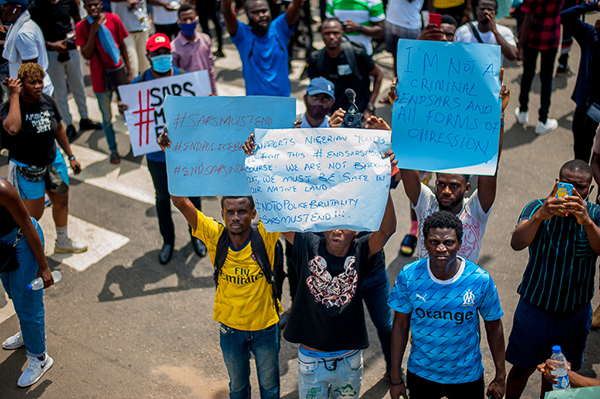 three kids with signs in Nigeria protest