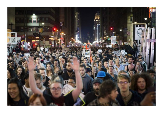 NYC, 11/24: Hundreds of people marched 100 blocks from Union Square to Harlem, and then stopped traffic on the Triborough Bridge. Here, protesters at Times Square. Photo: AP