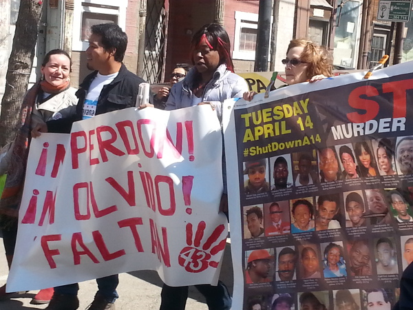 Chicago, 4 de abril. Gloria Pinex, madre de Darío Pinex quien fue asesinado por la policía de Chicago en 2011, lleva una manta junto con Omar, un estudiante de Ayotzinapa que sobrevivió la masacre y secuestro de estudiantes mexicanos de una escuela rural de profesores por parte de la policía el 26 de septiembre de 2014. La manta dice: '¡Ni perdón! ¡Ni olvido! Faltan 43'.