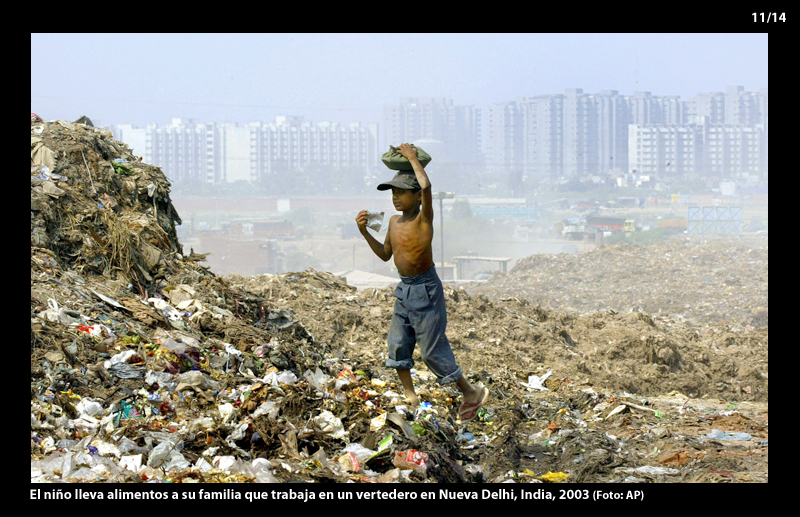 El niño lleva alimentos a su familia que trabaja en un vertedero en Nueva Delhi, India, 2003