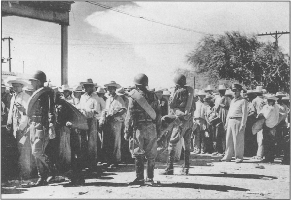 “Operation Wetback” was a U.S. government program of mass deportations of Mexican workers in the early 1950s. Above, Mexican officers guarding deportees awaiting train into Mexico at the Mexican side of the border. 