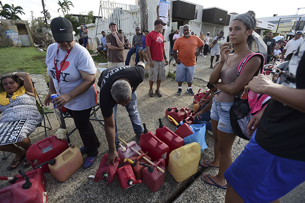 People wait in line for fuel distribution.