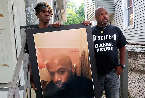 Joe Prude, brother of Daniel Prude, and Daniel's nephew Armin, with a picture of Daniel Prude