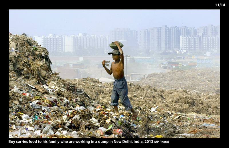 Boy carries food to his family who work in the dump in New Delhi, India, 2003