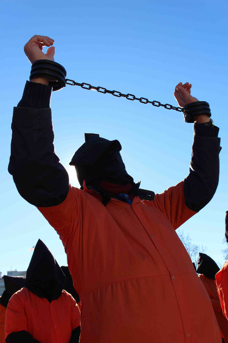 On the 14th anniversary of Guantánamo, protesters represented for the prisoners wearing orange jumpsuits and black hoods, from the White House gates to the West Coast, chanting and challenging passers-by with leaflets.