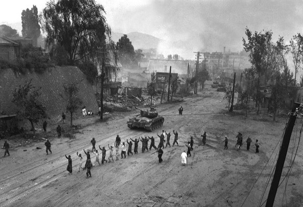 Marines in village street with prisoners.