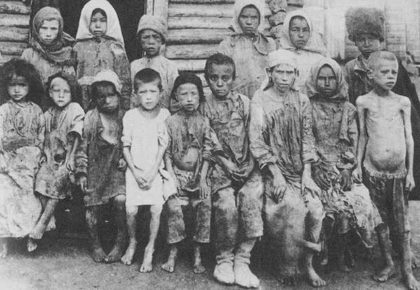 Quince niños hambrientos se sientan y representan una foto.