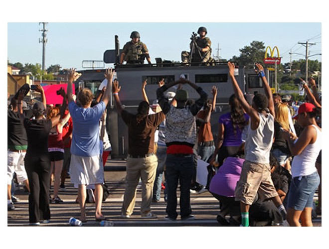 Protesters confront police who are on top their armored vehicle, Ferguson, August 13. Photo: AP 