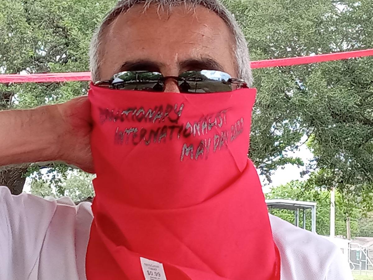 Person with red scarf that says Revolutionary May Day 2022