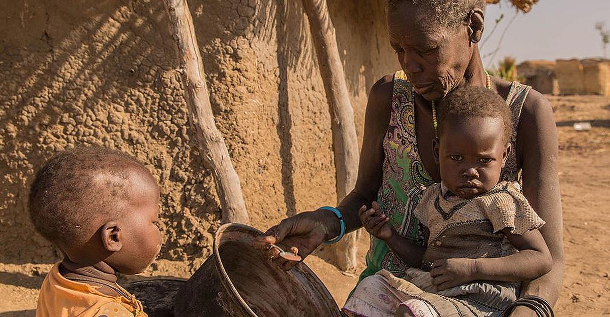 A Sudanese mother giving sorghum porridge to her children. 