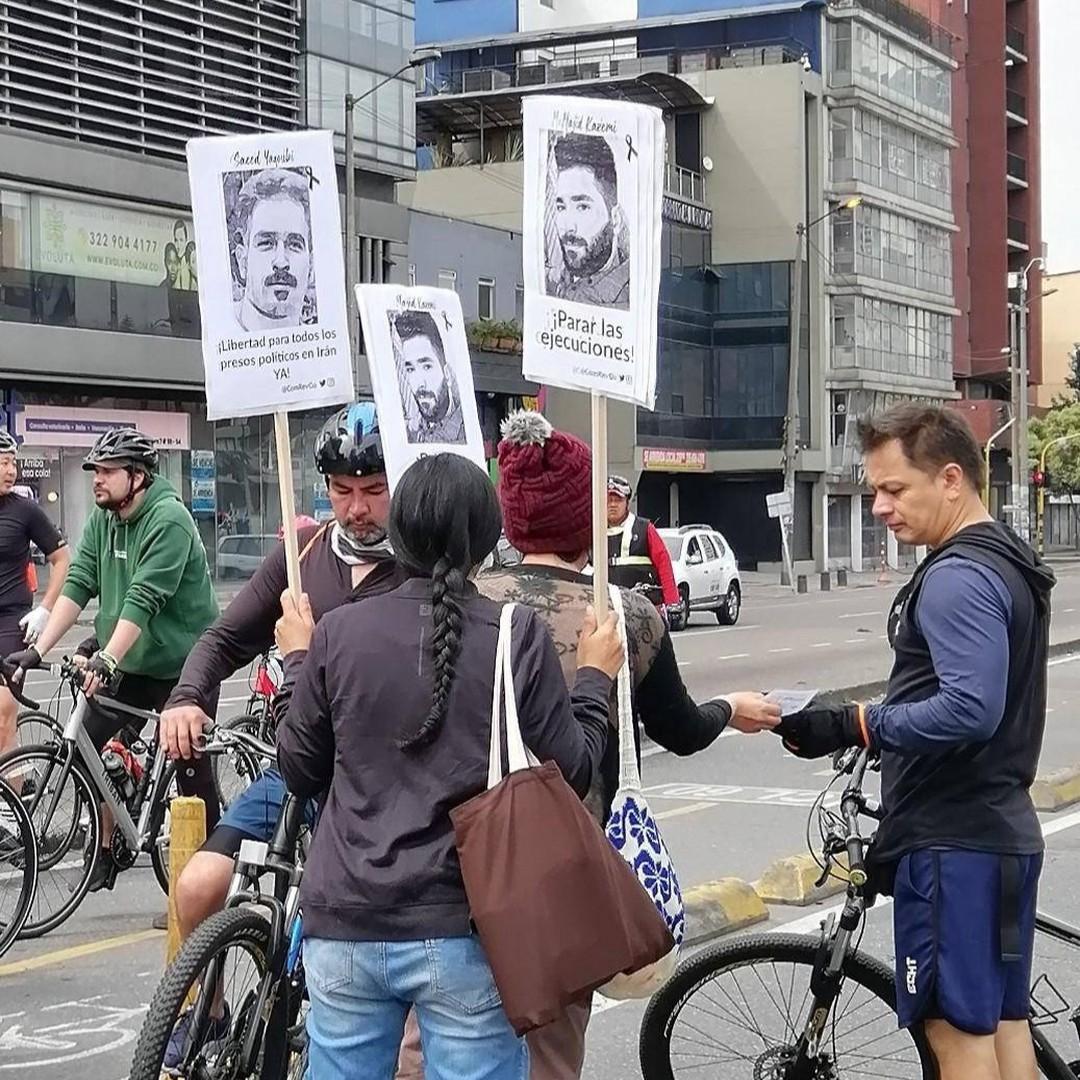 Holding posters of people executed in Iran, leafletting bicycle riders in Bogota, Colombia, to stop executions.