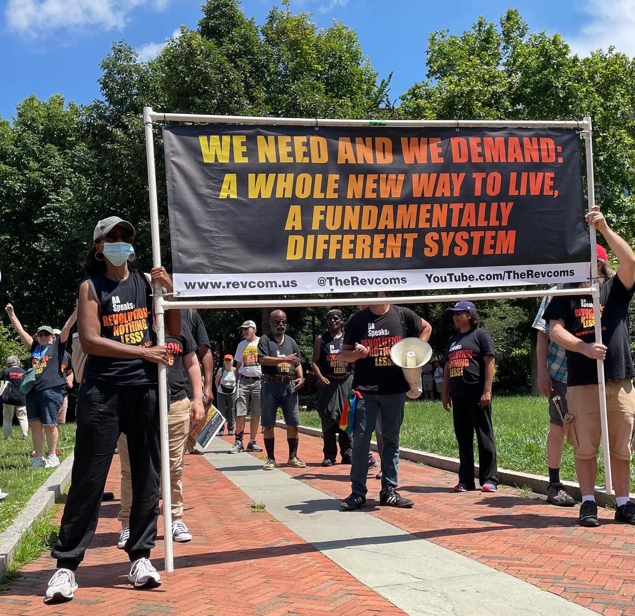 Revcoms line up to march behind banner "We Need and We Demand: A Whole New Way to Live..." 