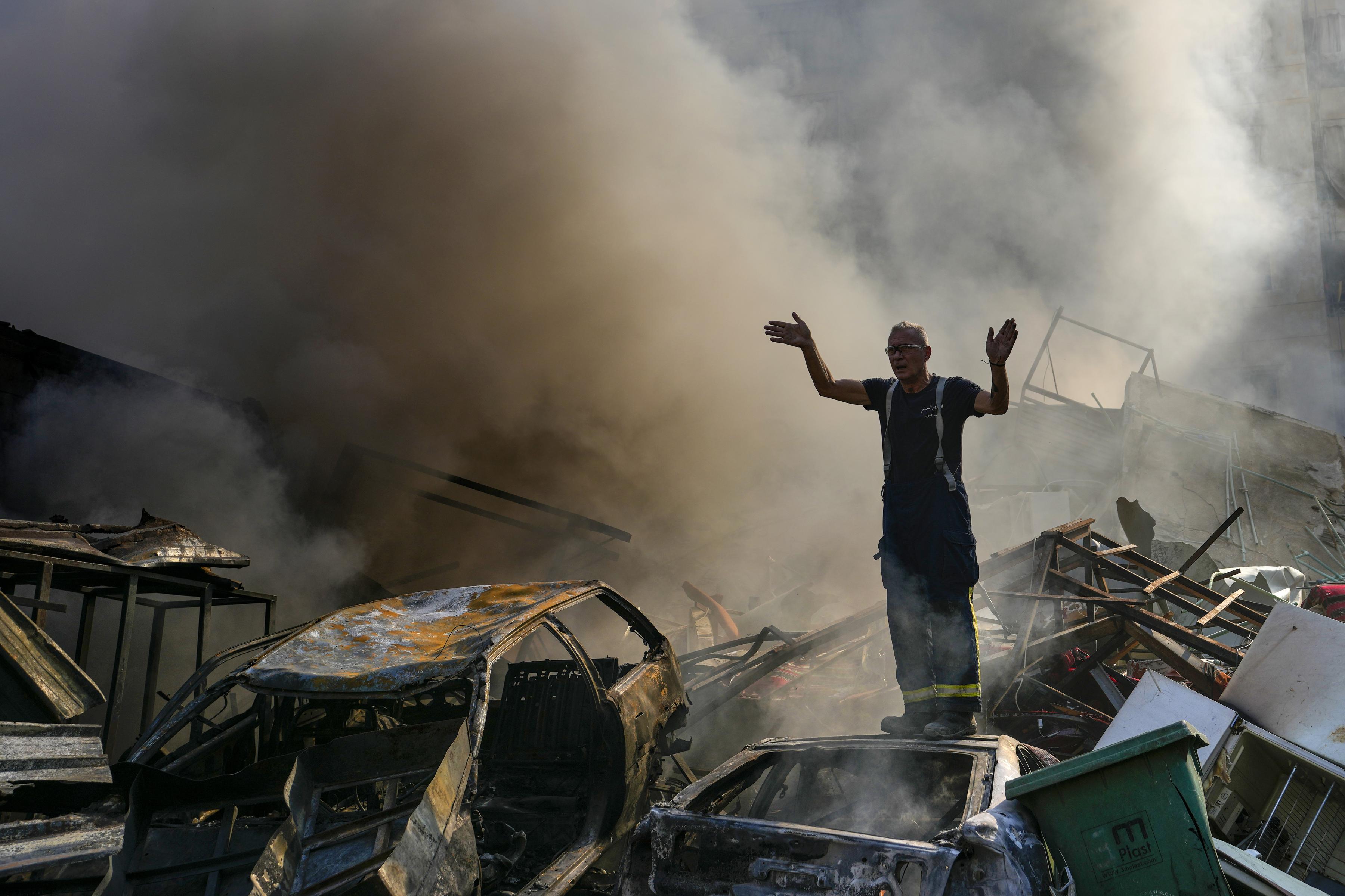 A civil defense worker gestures as smoke rises from the site of an Israeli airstrike in Dahiyeh, Beirut, Lebanon, Nov. 1, 2024.