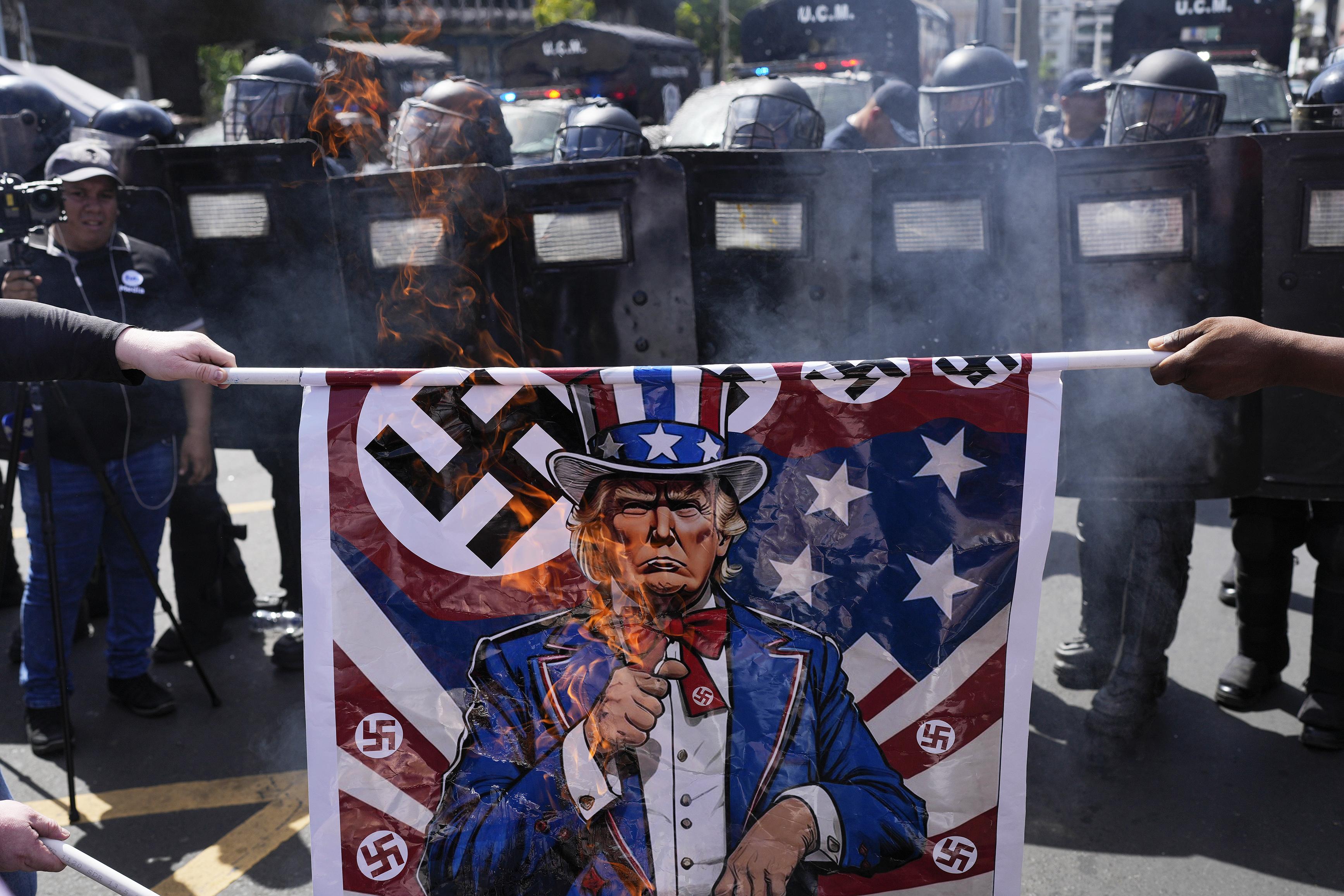 Burning poster of Trump and swastika at a rally protesting Marco Rubio's visit to Panama City,  February 2, 2025.