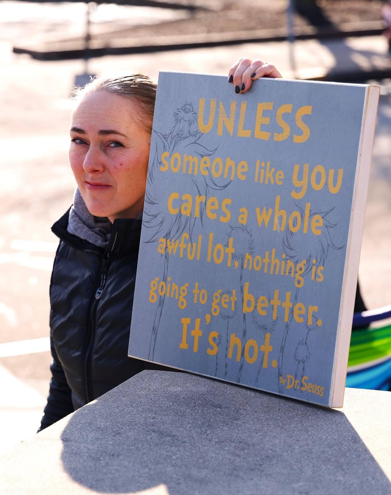 A woman in Muscatine, Iowa, holding up a quote from Dr. Seuss.
