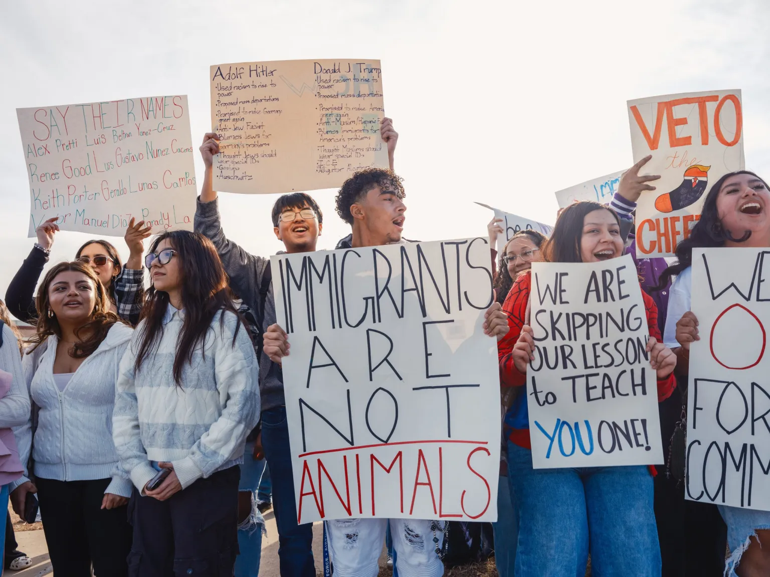 Students in Waco, Texas holding signs against Trump, supporting immigrants.