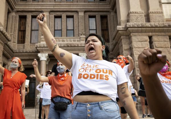 Women protest Texas six-week ban on abortion on Austin capitol steps.