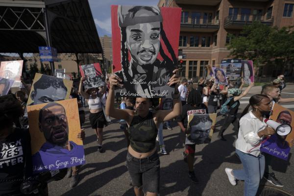 Protesters carry signs of people murdered by police at Derrick Chauvin trial.