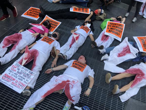 RevClub in bloody pants die-in Times Square to protest ban on abortion.