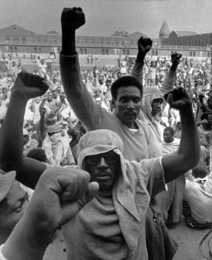 Attica prisoners with fists in the air.