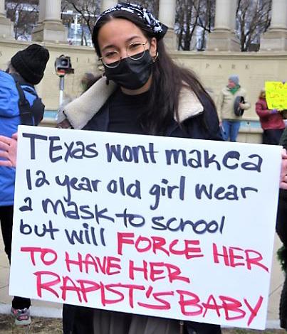 Chicago woman with sign about Texas not forcing face masks, but forcing women to carry babies from rapists.
