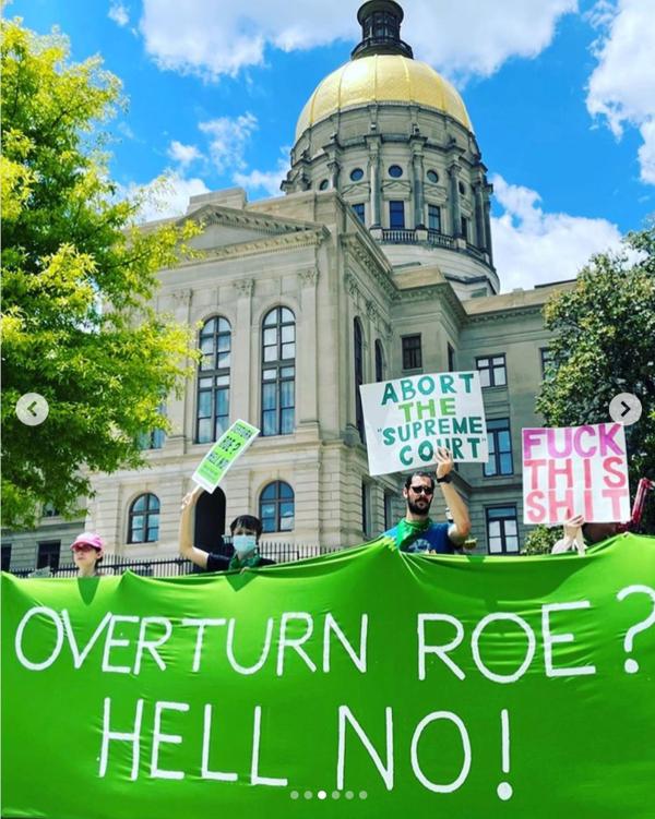 RU4AR hold green banner—Overturn Roe? Hell No!— in front of capitol building in Atlanta