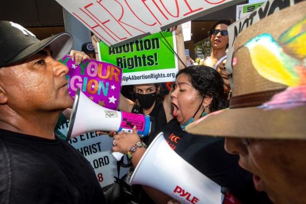 Youth on bullhorn lead chants at RU4AR rally in LA May 14