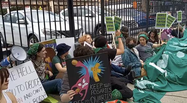 Students who walked out for abortion rights gather with green banner before marching to Lake Shore Drive.