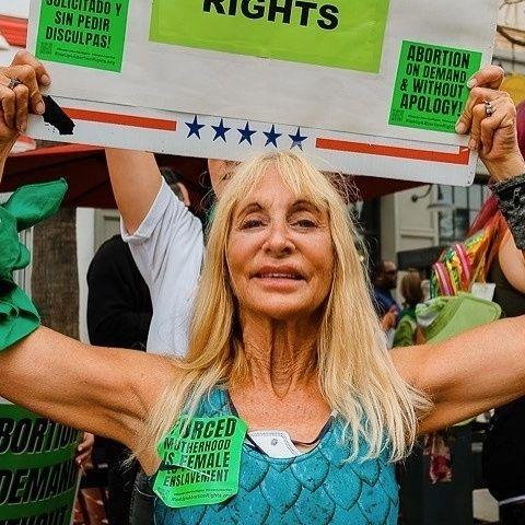 Santa Monica RU4AR activist with stickers and poster.