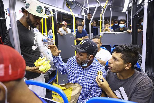 Immigrants share food on a bus set to transport them from the Texas border to refugee center in Chicago, August 31, 2022.