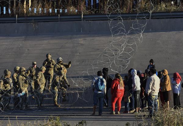 Immigrants stopped by Border Patrol and barbed wire at U.S. Mexico border, December 20, 2022.