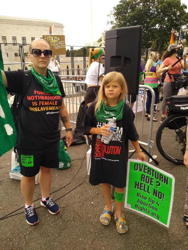 Protesters with sign: Overturn Roe? Hell no! Rise Up for Abortion Rights