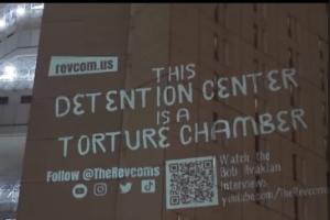 Projection on prison wall: This detention center is a torture chamber