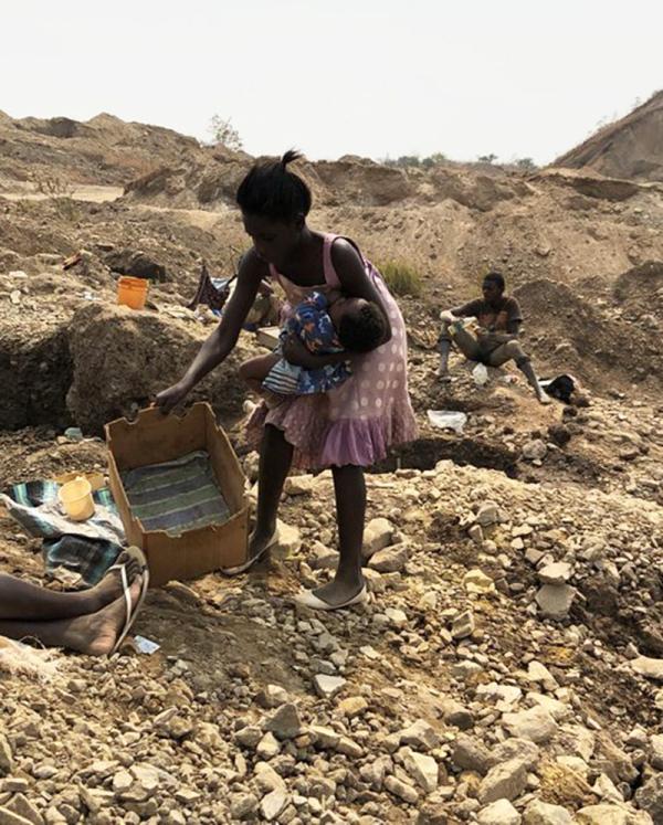 In Congo, a mother with her child mine for cobalt.