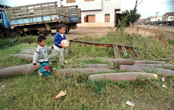 Children play near cluster bombs in Laos, 1997.