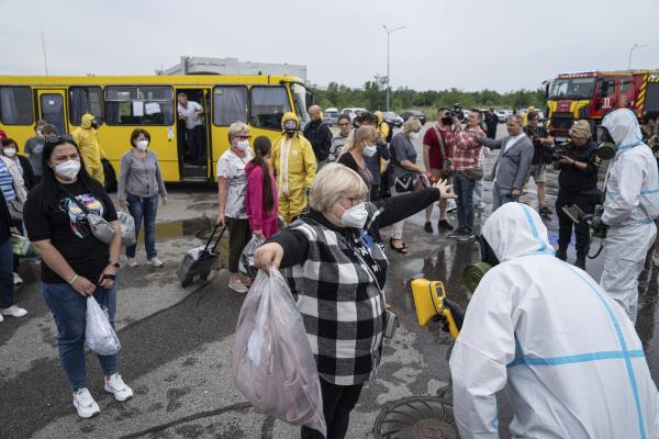 Ukrainian emergency workers wearing radiation protection suits check the radiation level of passengers of a bus in a drill near the Zaporizhzhia nuclear plant in Ukraine