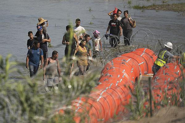 Migrants from Mexico stopped from crossing the Rio Grande by barbed wired buoys