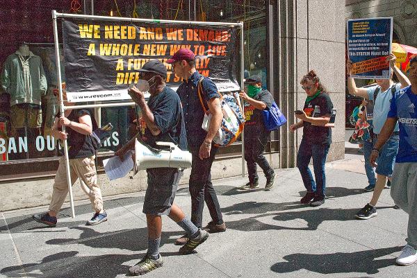 August 1, 2023, NYC: RevComs march to Roosevelt Hotel where migrants have to register.