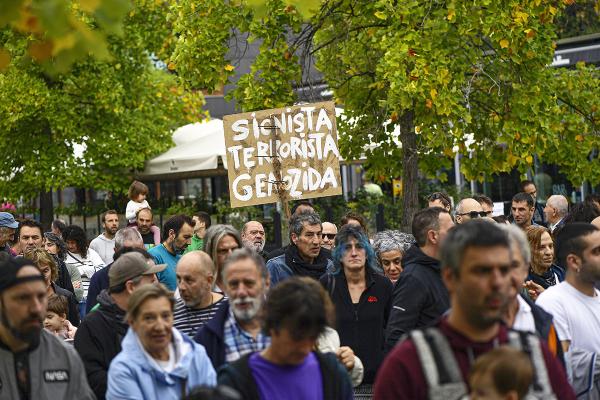 Palestinian supporter holds up banner reading: "Zionist. Terrorist. Genocide"