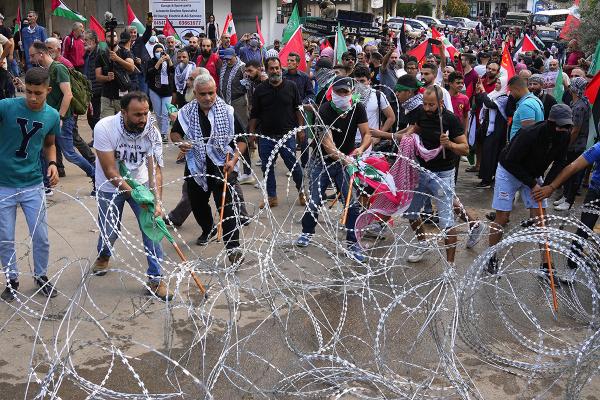 Beirut, Lebanon:  Protesters try to remove barbed wires that block a road leading to the U.S. embassy, during a demonstration in solidarity with the Palestinian people in Gaza, October 18, 2023.