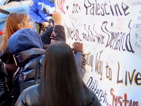 Harlem, New York City, youth sign banner during Week of Revolution, November 3, 2023.