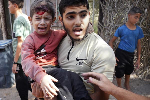 A wounded boy is carried after an Israeli strike in Deir Al-Balah, southern Gaza Strip, November 9, 2023.