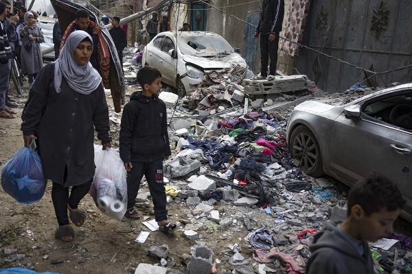 Woman and child walk through the destruction in Rafah, Gaza from Israeli airstrike, February 9, 2024,