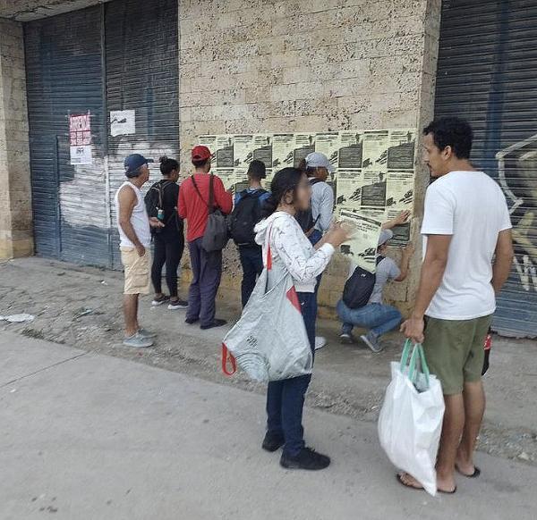 Colombia: people read graphic of BA's two outmodeds quote posted on wall.