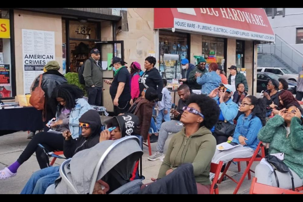 People outside Revolution Books NYC watching the eclipse: “The Eclipse Party at the Bookstore that Has the Whole World in Mind.”