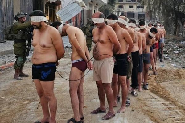 Stripped, blindfolded, and bound Palestinian civilians are taken prisoner and ordered into a line by Israeli occupation forces in Gaza in December 2023