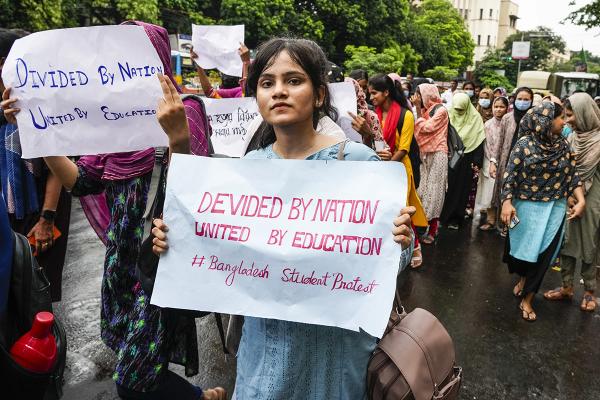 Students of Alia University, India, with signs that say "Divided by nation, united by education," march in solidarity with protesting students in Bangladesh, July 22, 2024. 